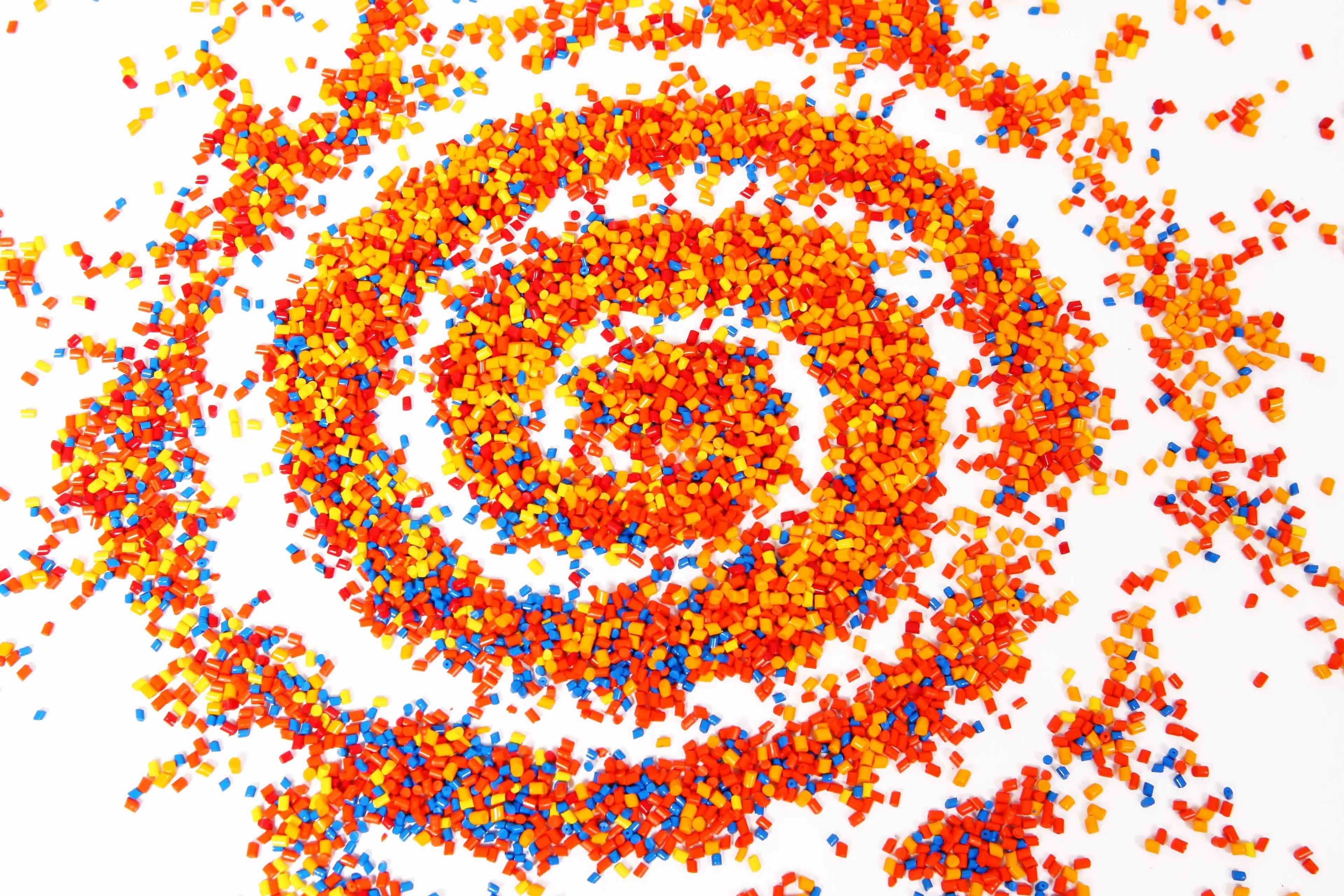 Swirl of colourful plastic beads on white background